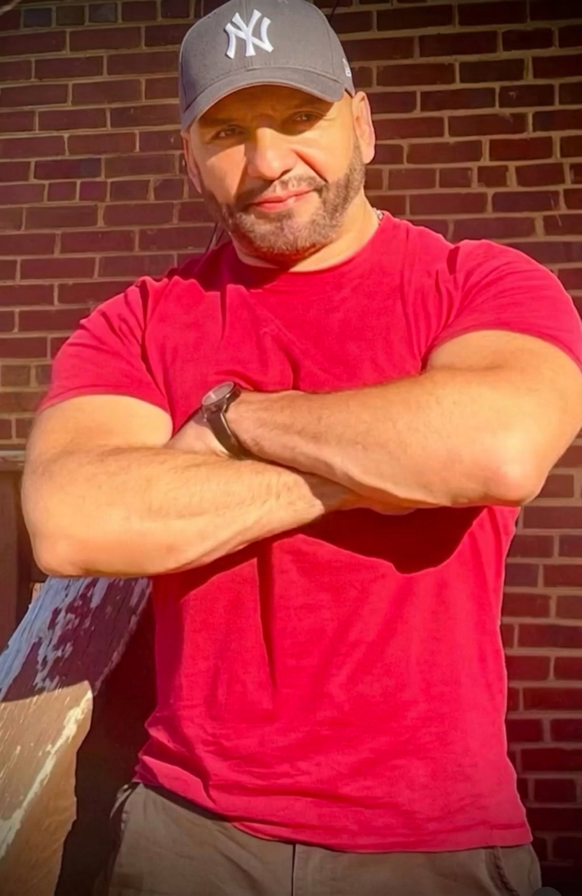 Steve Cas, graphic designer and celebrity artist, in front of a brick wall